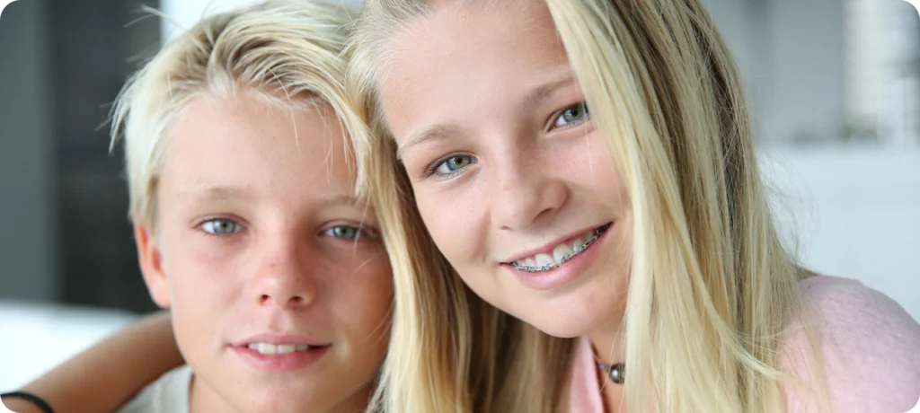 Deux adolescents souriants, dont l’une porte un appareil orthodontique